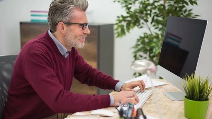 Un hombre madura trabaja frente a su ordenador