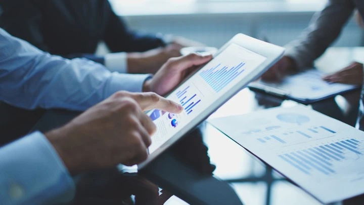 Un hombre manipula o consulta datos financieros en una tablet.